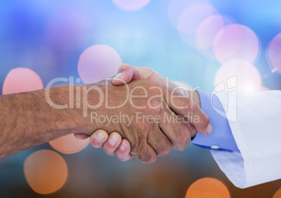 Hands shaking with sparkling light bokeh background