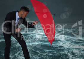 Business man behind umbrella against stormy sea with bokeh