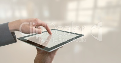 Businessman holding tablet in bright office