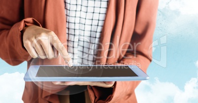 Woman orange coat mid section with tablet against sky and flare