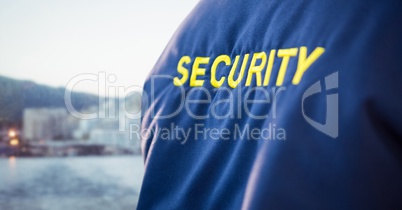 Back of security guard jacket against blurry skyline