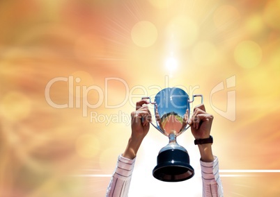 businesswoman hands with trophy. Gold background with flares