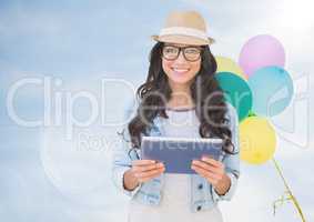 Trendy woman with tablet against sunny sky and balloons with flare