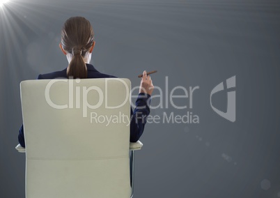 Back of seated business woman smoking cigar against grey background with flare