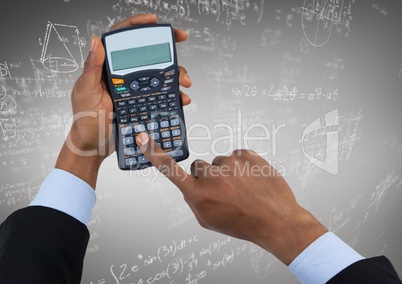 Hands with calculator against white math doodles and grey background