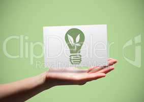 Hand with card showing green lightbulb graphic against green background