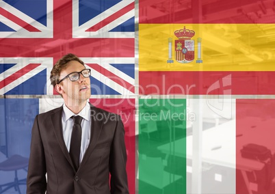 main language flags around young businessman thinking. office background