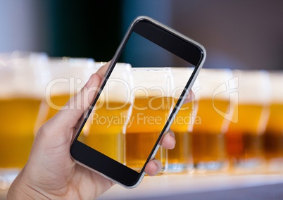 Hand of person taking a picture of beers  with her smartphone