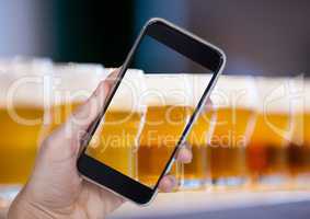 Hand of person taking a picture of beers  with her smartphone
