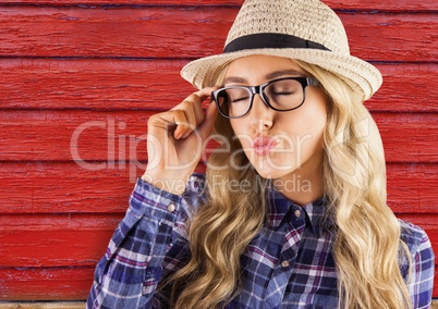 hipster woman with glasses sending a kiss with red wood background