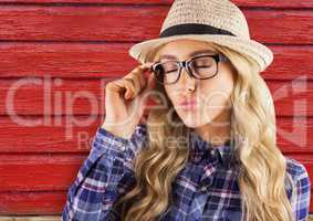 hipster woman with glasses sending a kiss with red wood background