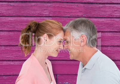 couple looking each other with pink wood background