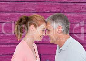 couple looking each other with pink wood background