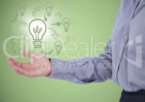 Business woman mid section with lightbulb doodles and flare in hand against green background