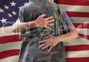 soldier hugging family in front of usa flag