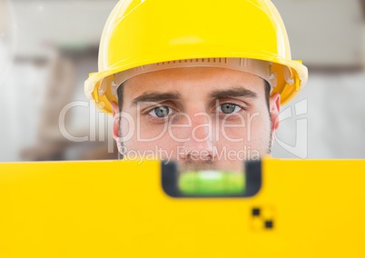 Construction Worker with spirit level in front of construction site