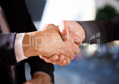 foreground of handshake in the city