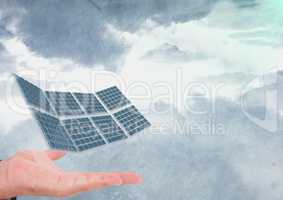 Cropped image of hand with solar panel against cloudy sky