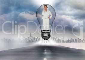 Digital composite image of businesswoman standing in bulb on road against cityscape