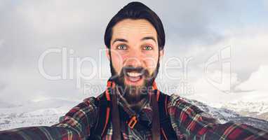 Hipster taking selfie while standing on mountain against sky