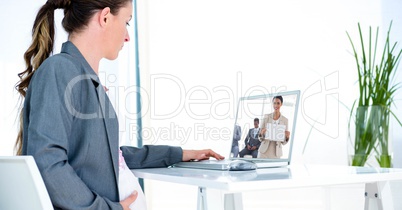 Side view of pregnant businesswoman video conferencing in office