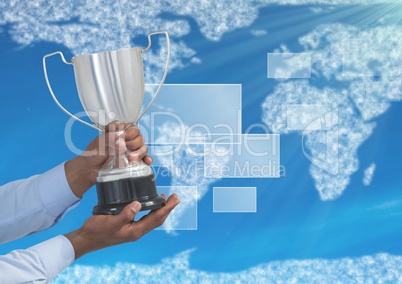 Digital image of hands holding trophy against world map