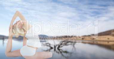 Double exposure of beautiful woman doing yoga and lake against sky