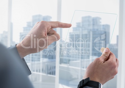 Businessman holding glass tablet against window