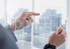 Businessman holding glass tablet against window