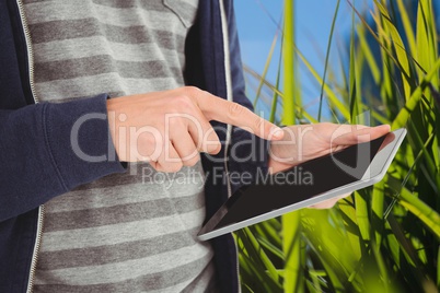 Model touching tablet computer screen against nature background