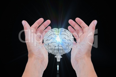 Brain between two hands with black background