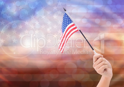 Hand with American flag with sparkling light bokeh background