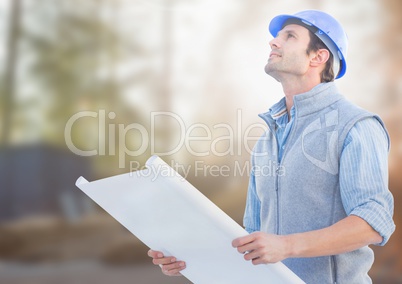 Architect with blueprints on building site