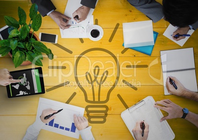 Overhead of business team with yellow wood panel and lightbulb graphic