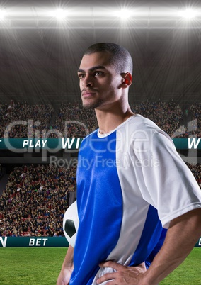 Football player holding a football in a stadium