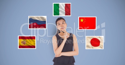 Beautiful woman holding pen and thinking while standing by flags against blue background