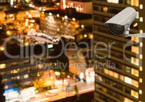 CCTV camera against illuminated buildings in city