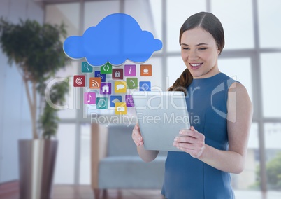 Businesswoman holding tablet with apps icons in office by window