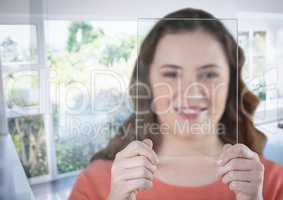 Woman holding glass screen by sunny window