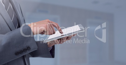 Businessman holding tablet next to grey elevator lifts