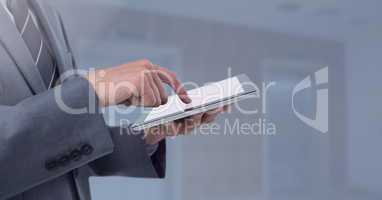 Businessman holding tablet next to grey elevator lifts