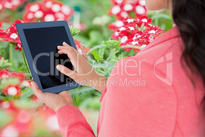 Brown-hair girl using tablet with flowers background