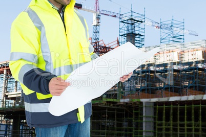 Engineer watching plans on construction site