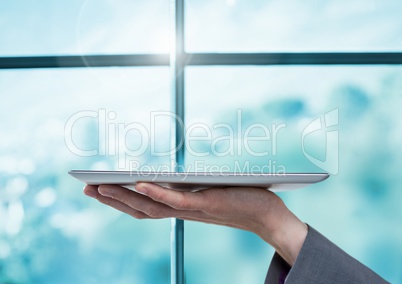 Businesswoman holding tablet by window
