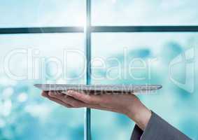 Businesswoman holding tablet by window