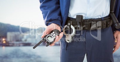 Security guard lower body with walkie talkie against blurry skyline
