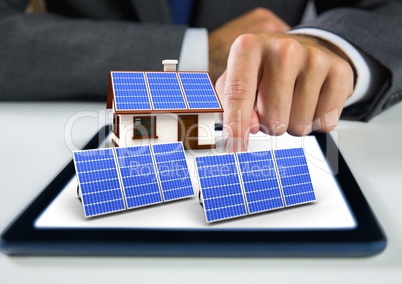 solar panel and house with solar panel on tablet with businessman hand