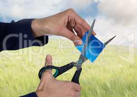 Hands cutting bank card in nature