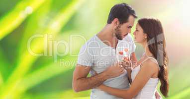 Couple holding champagne glass in front of green background