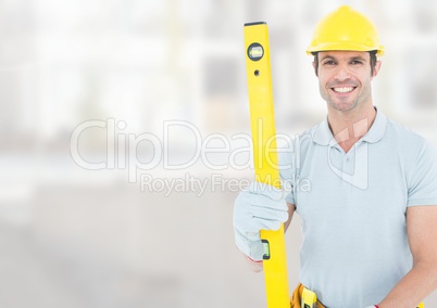 Construction Worker with spirit level in front of construction site